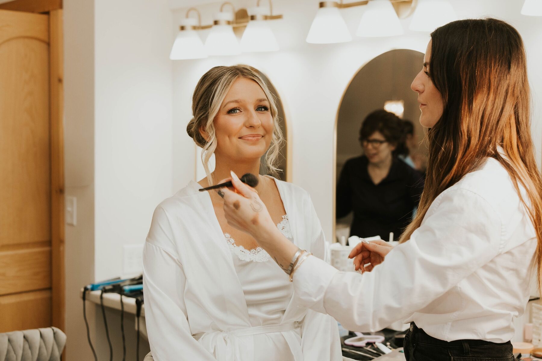Bride getting makeup applied before ceremony